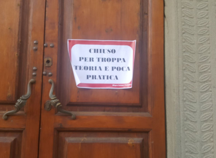 Uno dei cartelli ironici appesi fuori da una chiesa a Bagni di Lucca