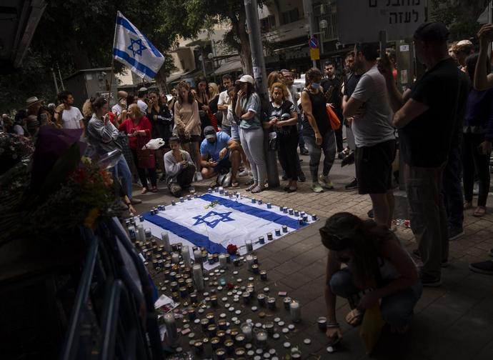 Gente in preghiera sul luogo della sparatoria a Tel Aviv