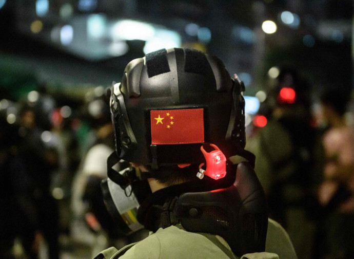 Poliziotto anti-sommossa con insegne cinesi a Hong Kong